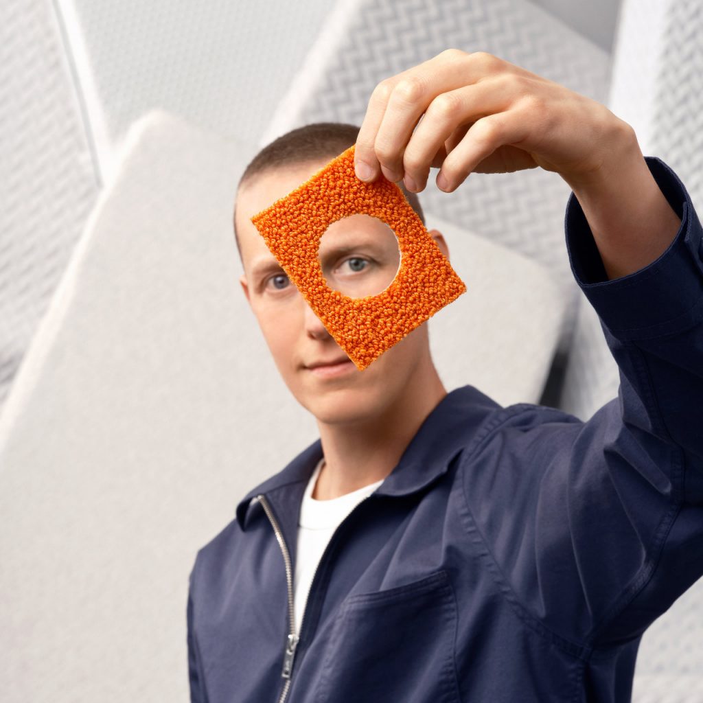 A man looking through a hole in a carpet, symbolizing transparency.